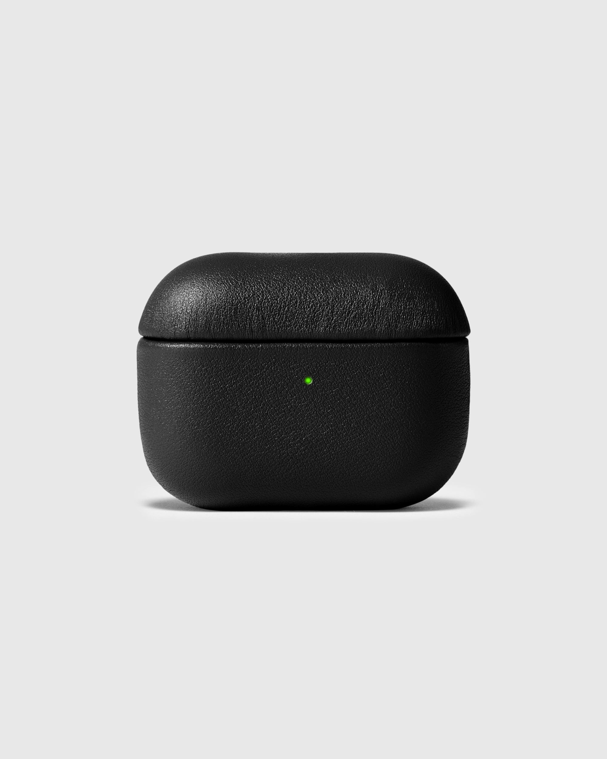 Black genuine leather AirPods case closed with the green status light visible