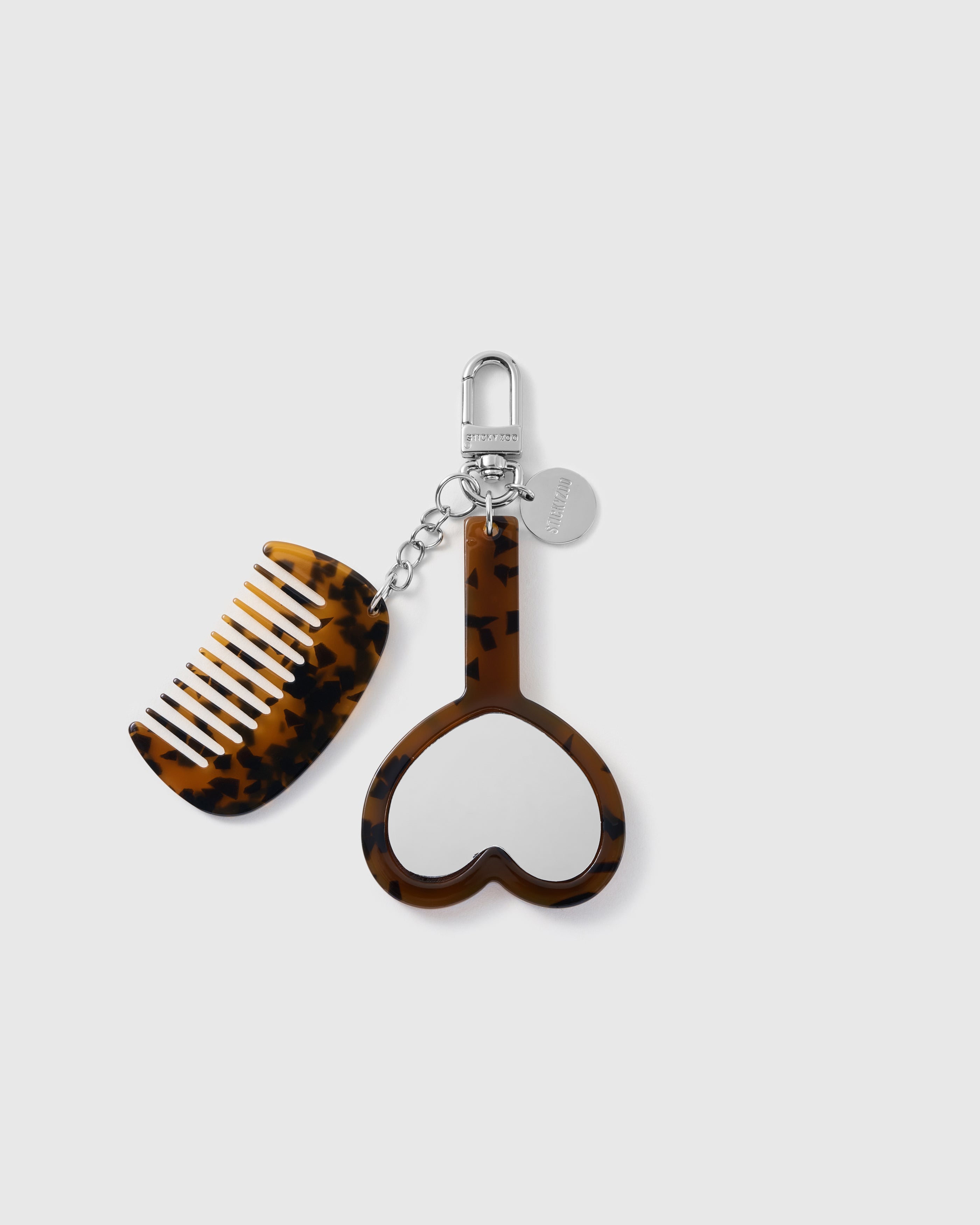 STICKYZOO brown tortoiseshell-pattern vanity stack charm with separate crescent comb, heart mirror and silver-tone clasp hardware.