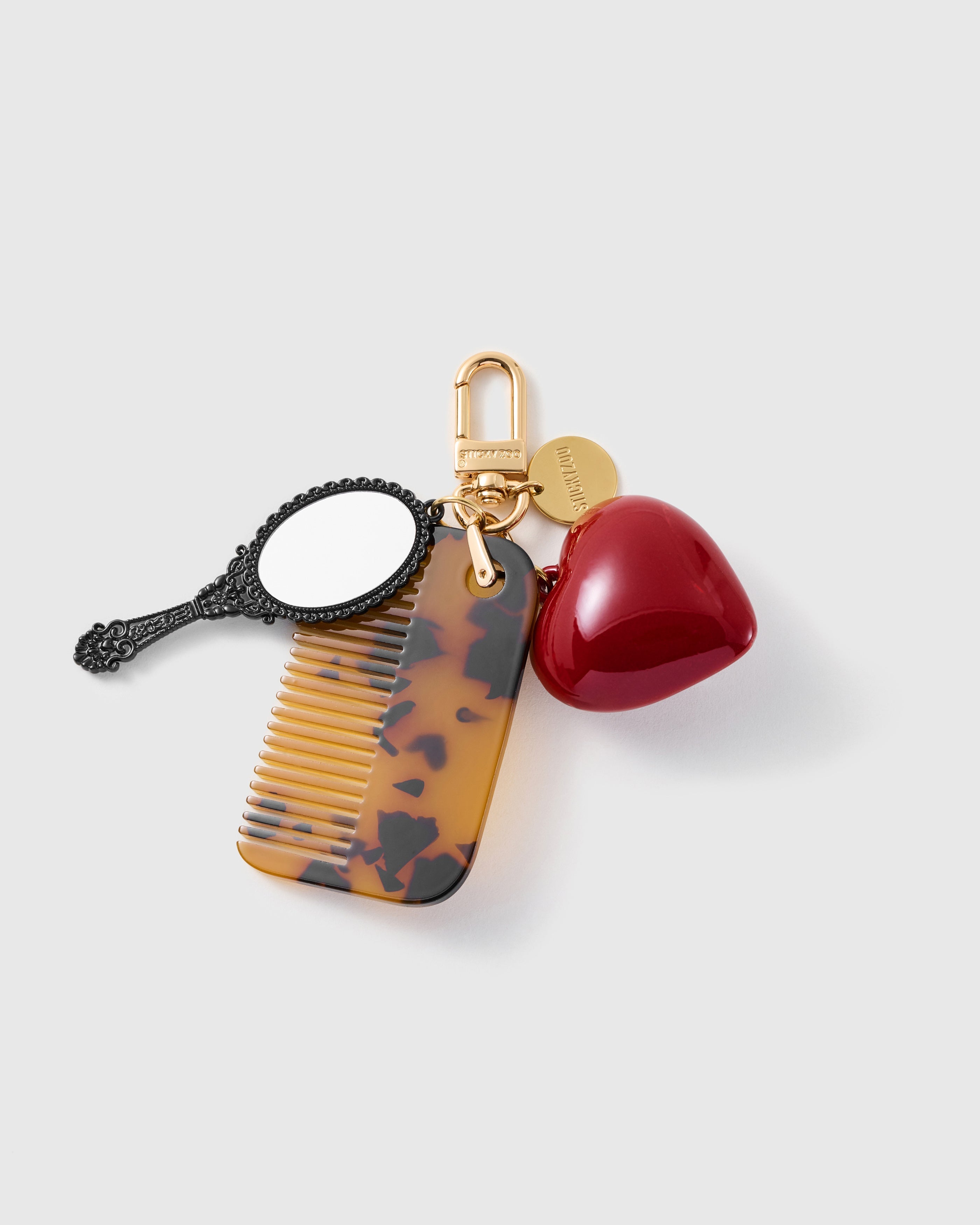 STICKYZOO Scarlett Love Note Vanity Stack Charm with a black hand mirror, tortoiseshell-pattern comb and glossy red heart on a gold-tone clip