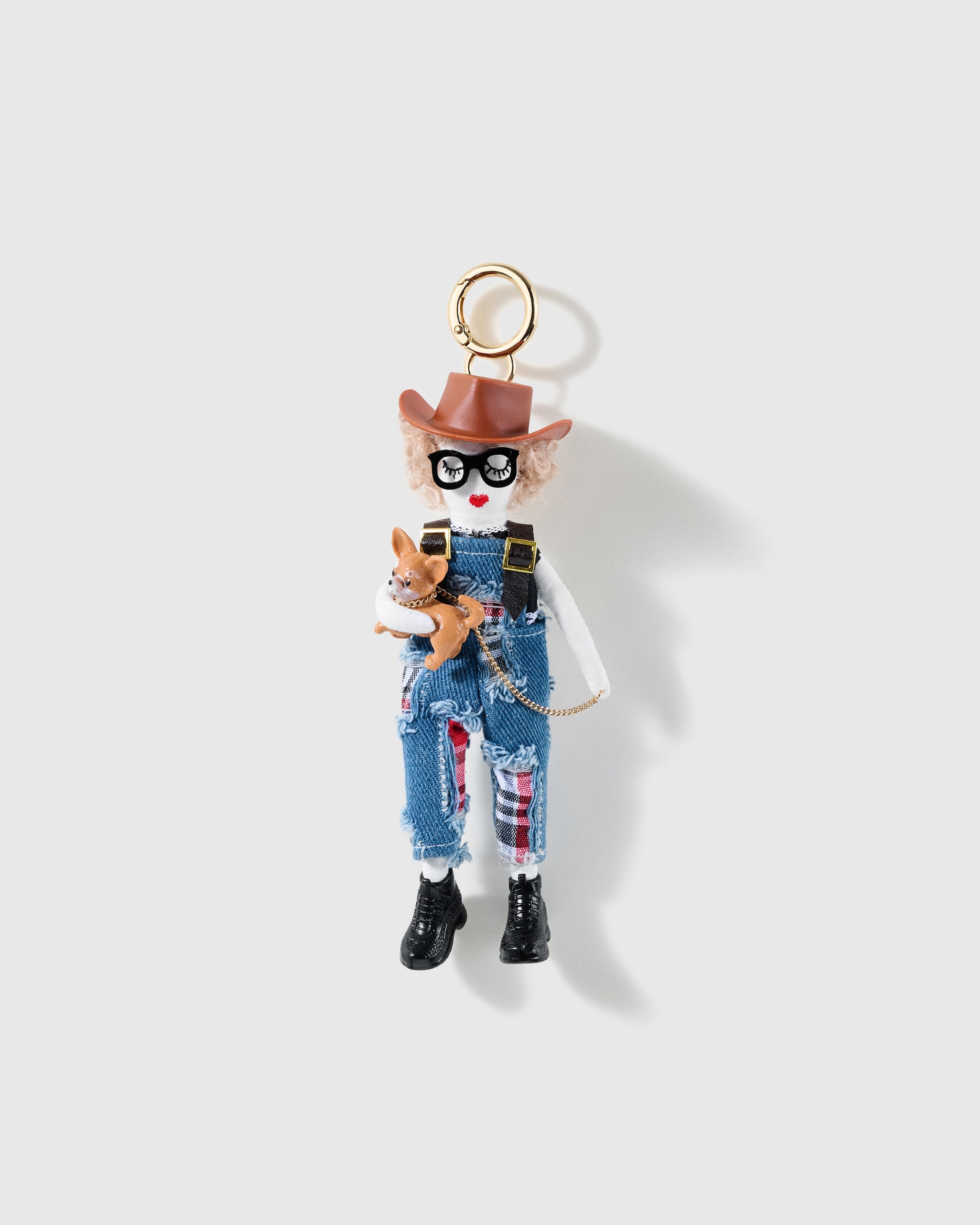 Cowgirl charm wearing a brown hat and denim-look overalls while holding a tiny Chihuahua figure