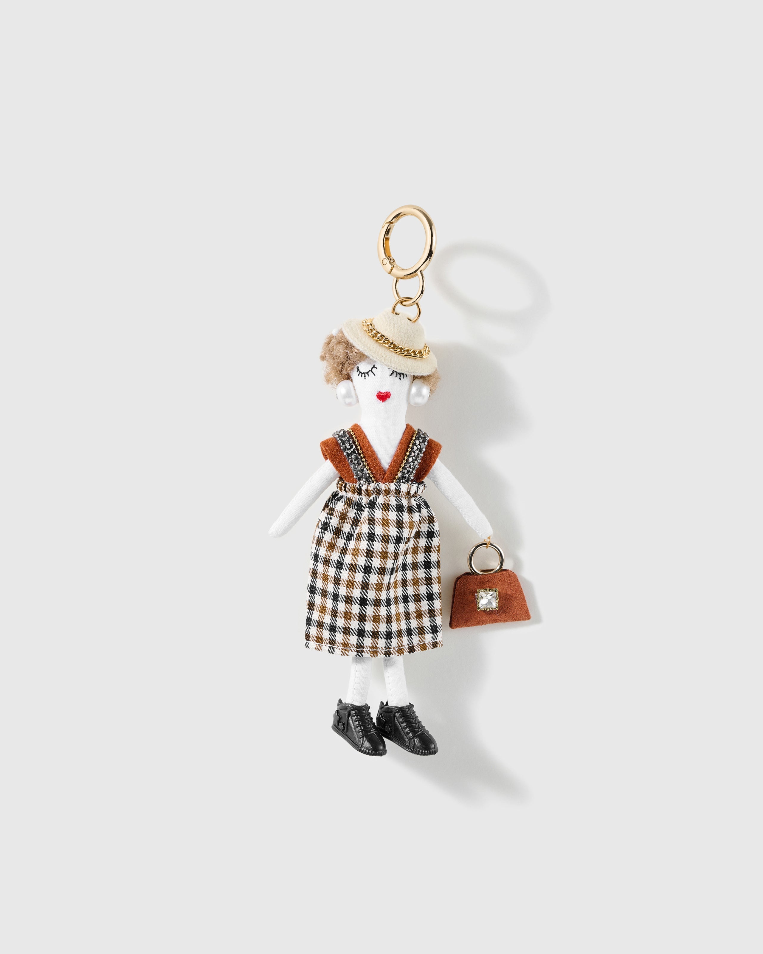Cocoa Check Handbag Charm, textile character with cream beret, cocoa check outfit, brown handbag and black shoes, on a light background
