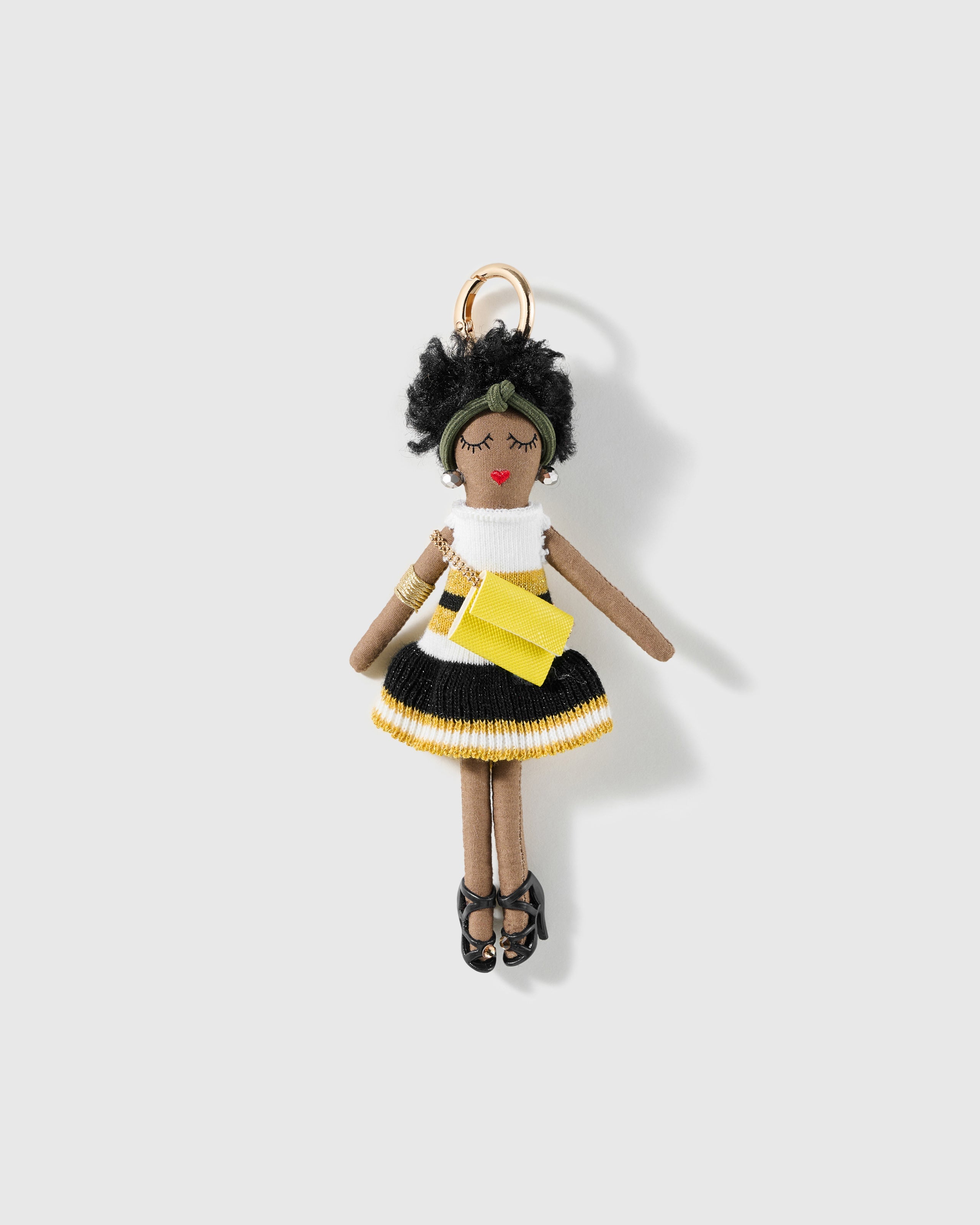 Sunny Envelope Charm, textile character with olive headband, patterned dress, yellow envelope bag and black shoes, on a light background