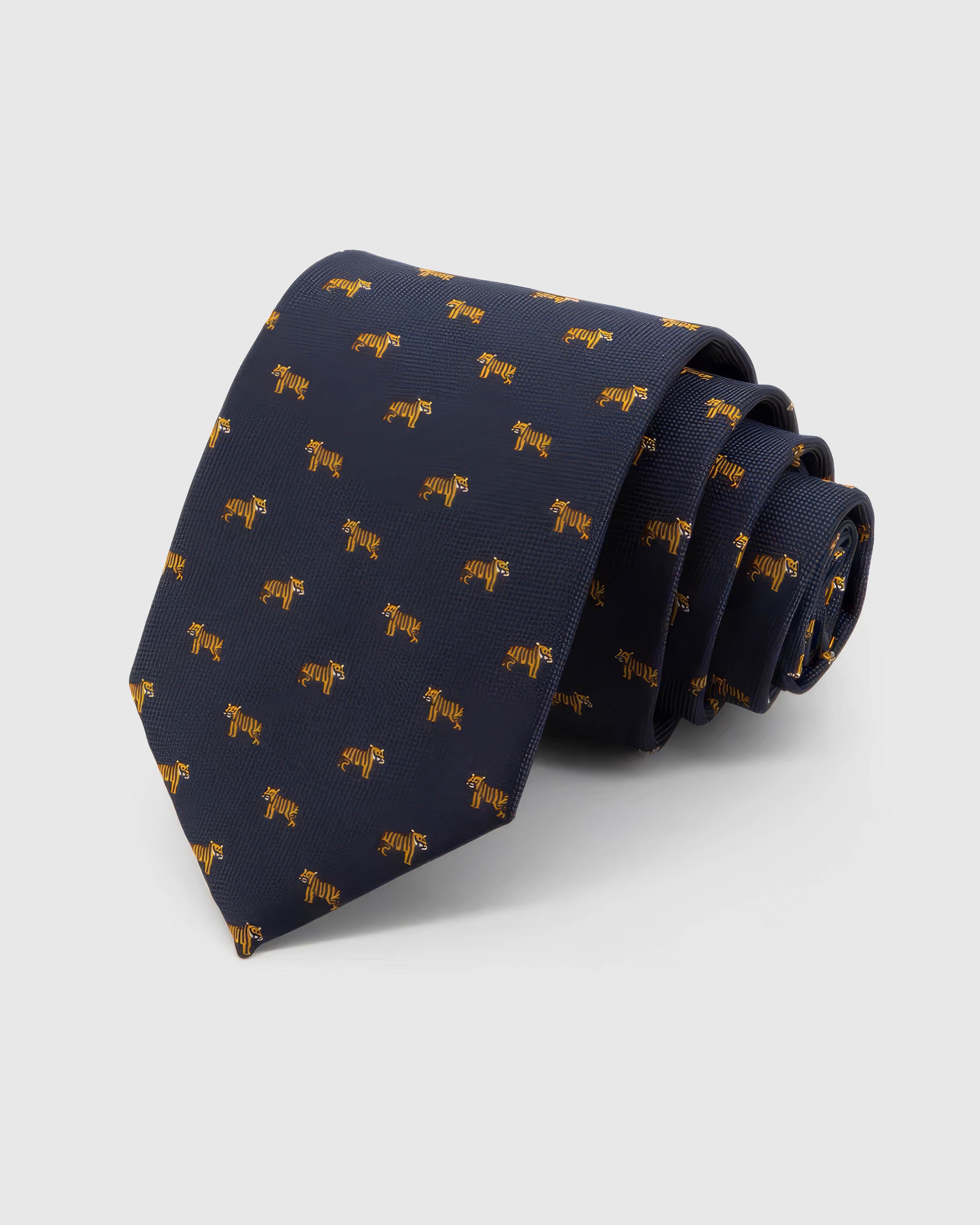 STICKYZOO Midnight Golden Tiger Tie in midnight navy silk, rolled to show midnight ground with compact golden tiger motifs across the blade.