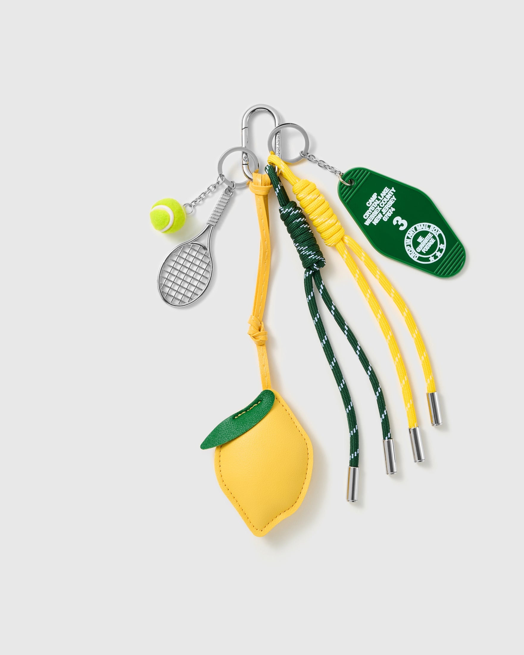 Lemon Tennis Stack Charm with a yellow lemon, tennis motifs, green stitched patch and yellow-and-green cords on a light background