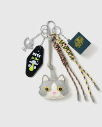 Silver Cat Lucky Stack Charm with a silver cat face, lucky tag, dice details and neutral braided cords on a light background