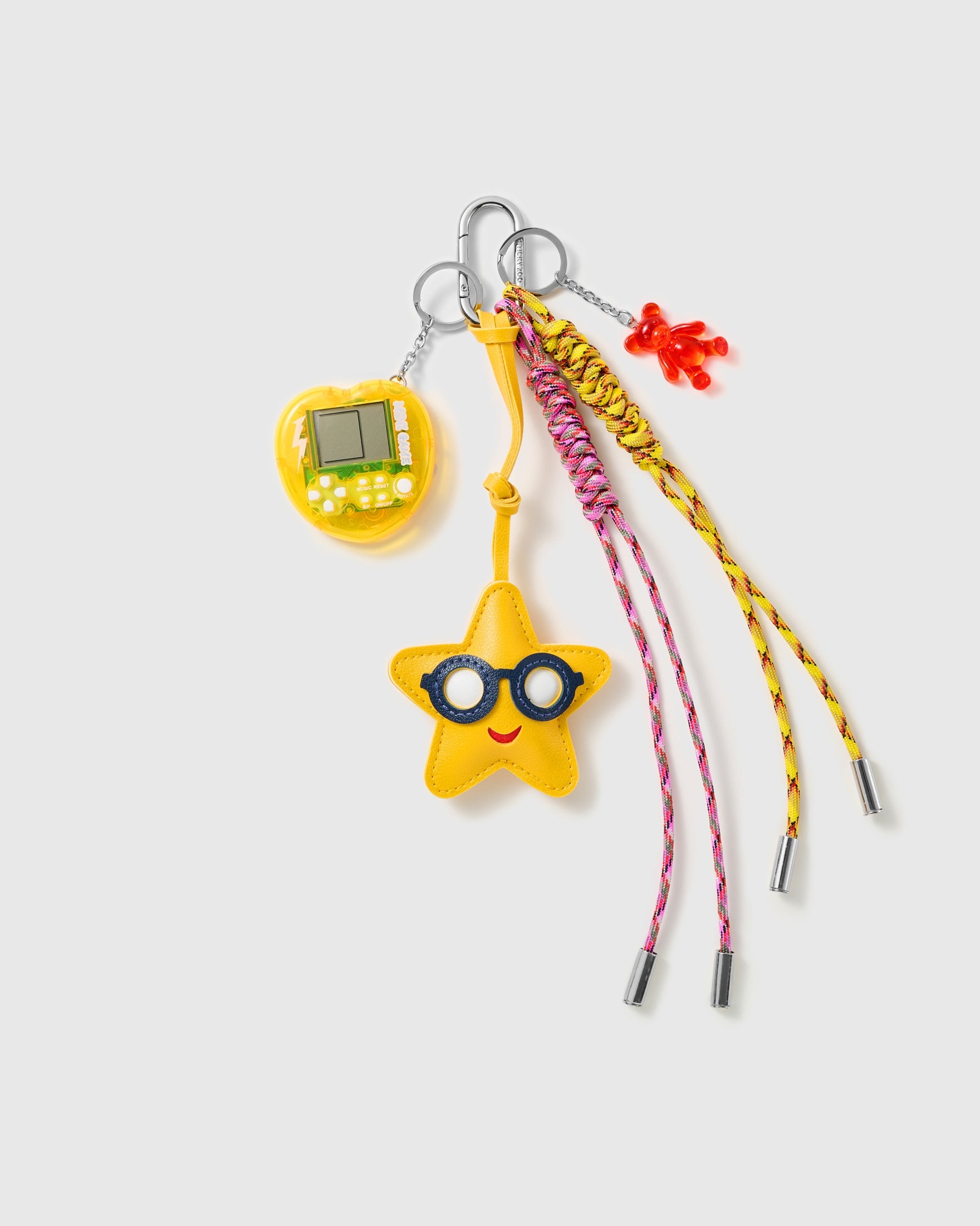 Star Player Game Stack Charm with a glasses-wearing star, yellow handheld-game motif and pink-and-yellow cords on a light background