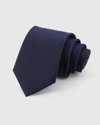 STICKYZOO Midnight Micro-Square Tie in midnight and indigo silk, rolled to show midnight and indigo dense micro-square grid across the blade.