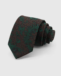 STICKYZOO Emerald Baroque Scroll Tie rolled on white, showing a dark brown-black ground with large emerald baroque scrolls and botanical flourishes across the front blade.