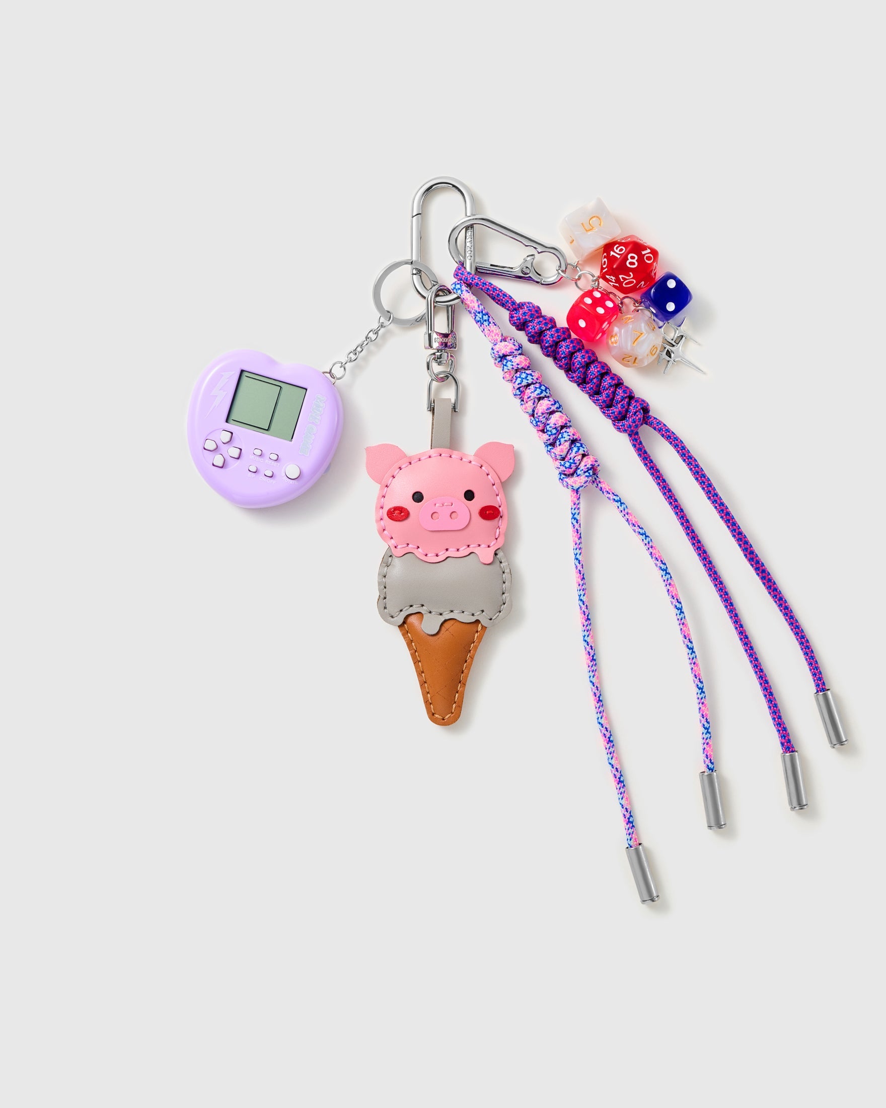 Ice Cream Arcade Stack Charm with a pink ice-cream character, purple handheld-game motif, dice and purple cords on a light background