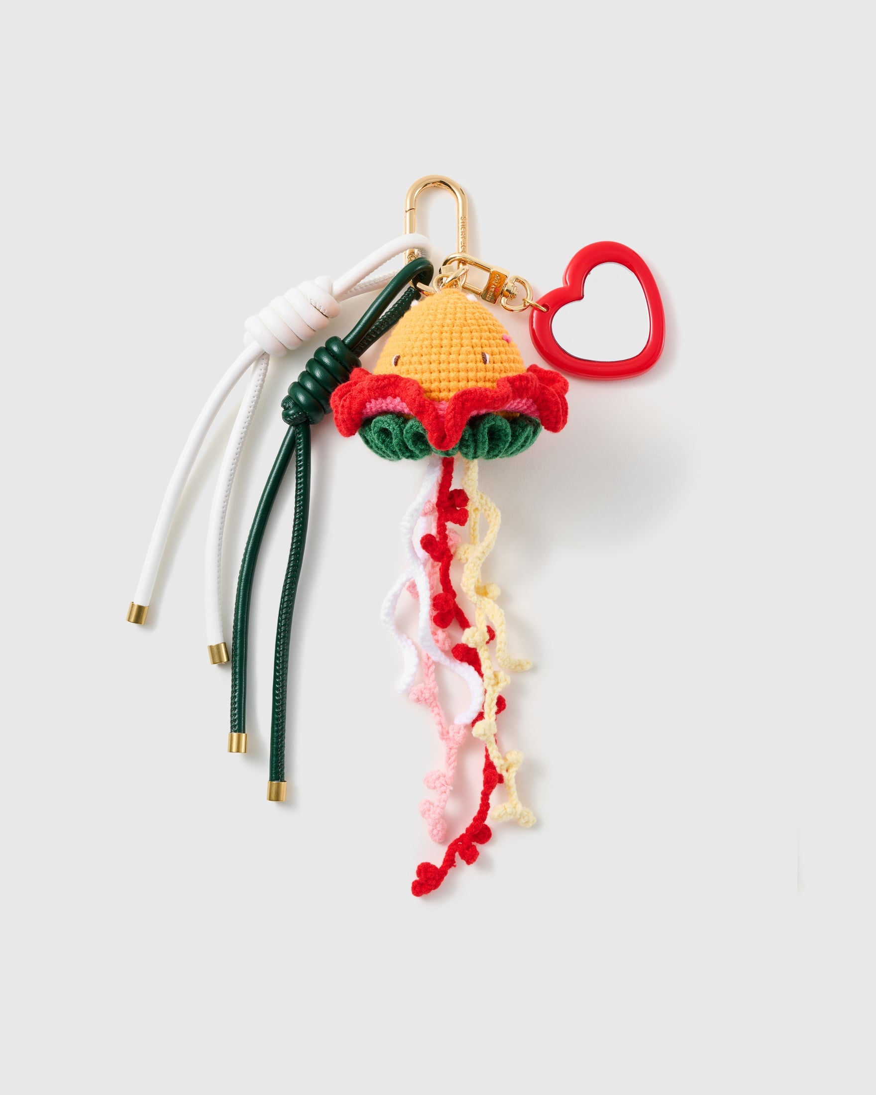 Burger & Noodles Gold Stack Charm with a burger motif, noodle-like tassels, red heart outline and green-and-white cords on a light background