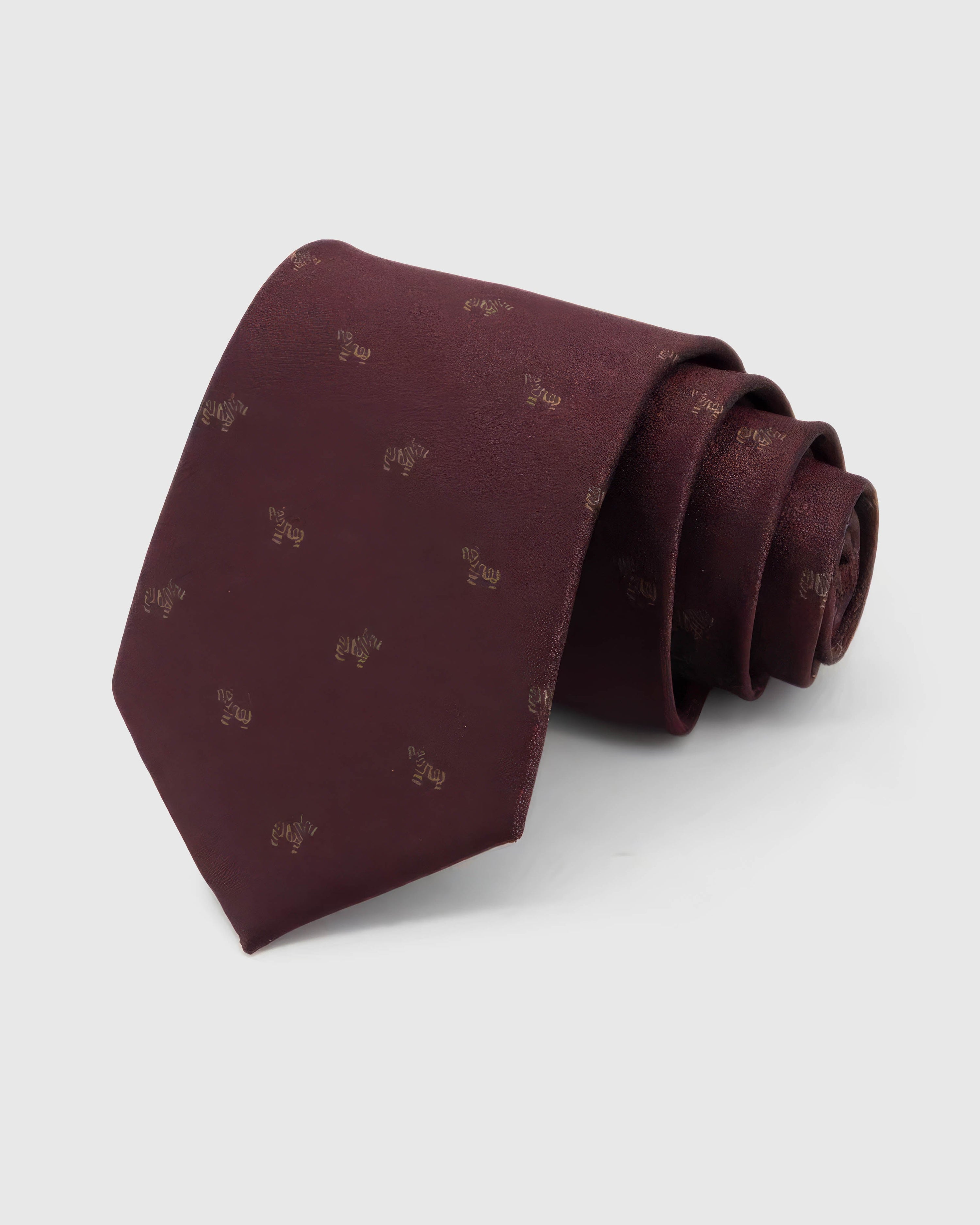 STICKYZOO Burgundy Glyph Tie rolled on white, showing a burgundy ground scattered with small muted-gold calligraphic glyphs across the front blade.