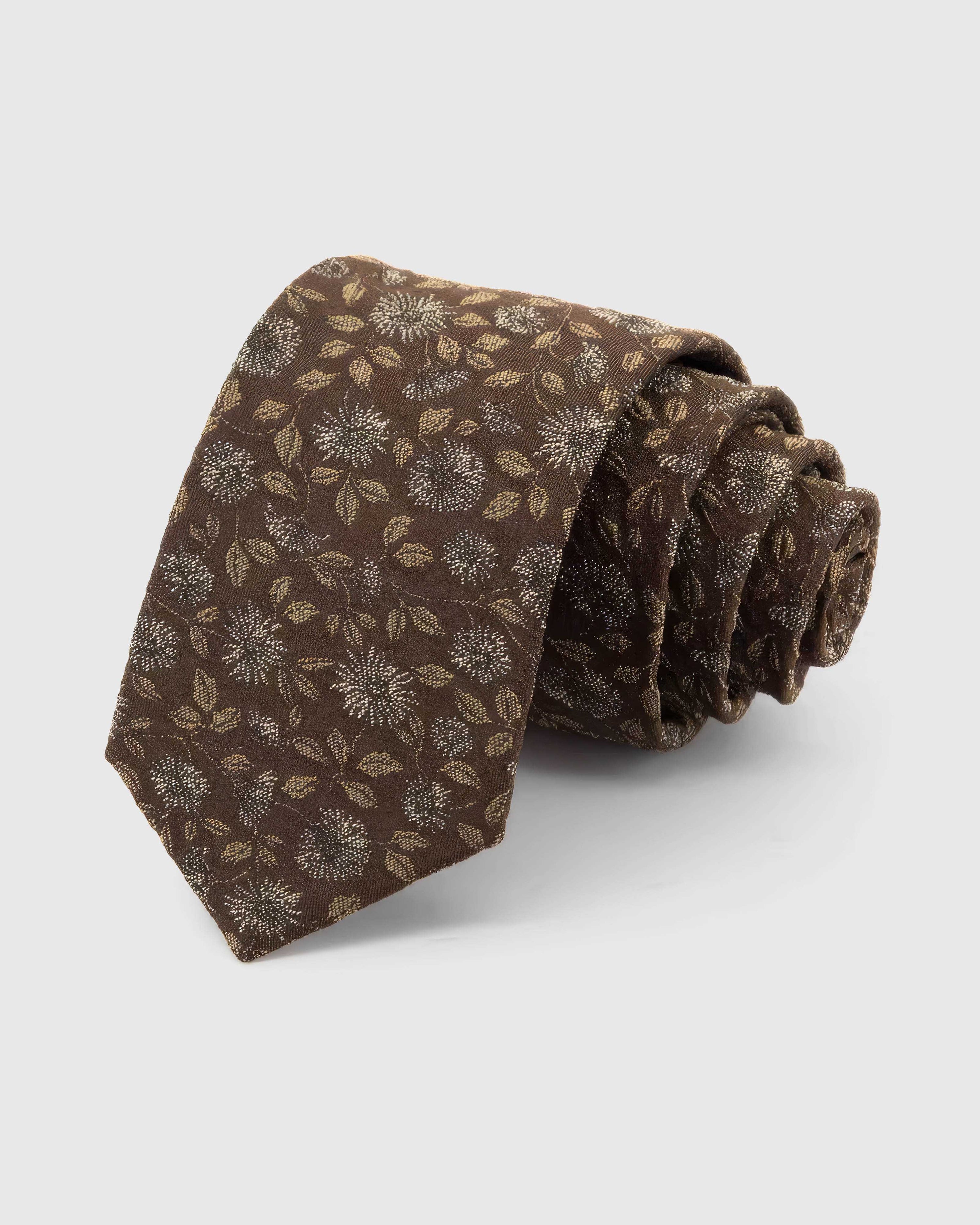 STICKYZOO Espresso Ivory Bloom Tie rolled on white, showing an espresso ground with ivory flowers, muted-gold petals, and soft botanical leaves across the front blade.