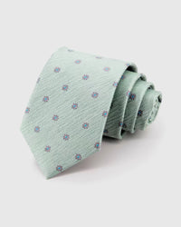 STICKYZOO Sage Blossom Tie rolled on white, showing mauve micro blossoms across 100% mulberry silk in sage mint