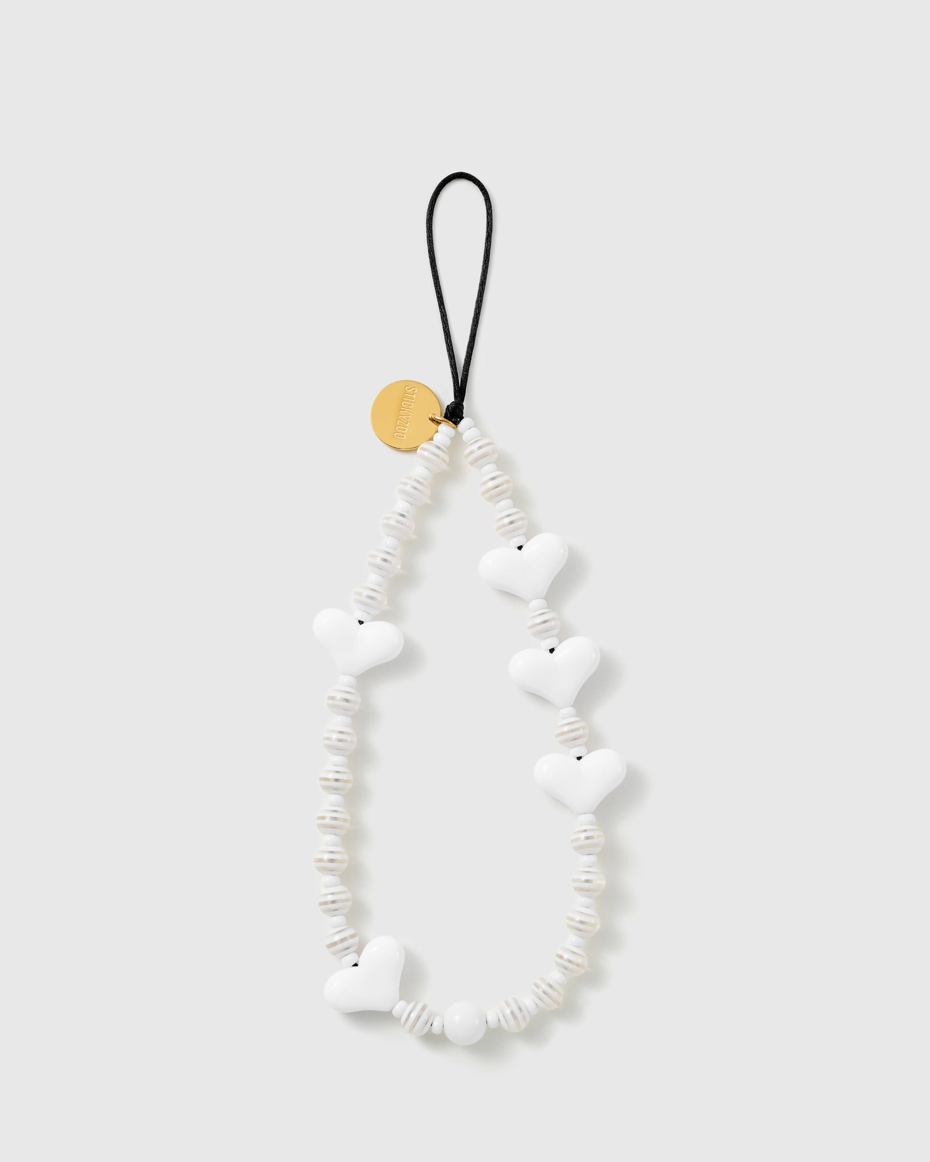 STICKYZOO Snow Heart phone strap with glossy white puffy hearts, ribbed cream-white disc beads, a gold-tone disc and black cord loop.