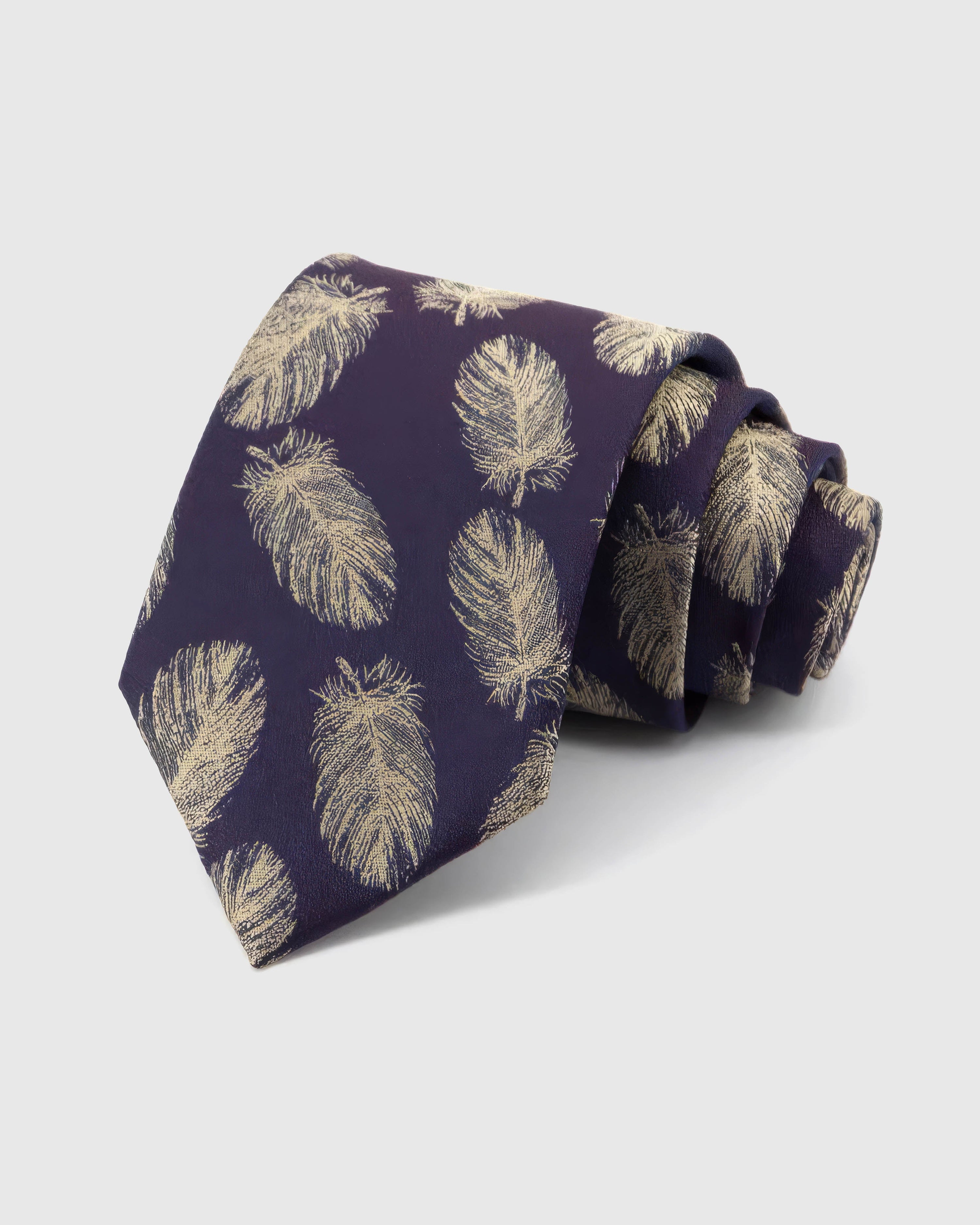 STICKYZOO Aubergine Gilded Feather Tie rolled on white, showing a deep aubergine ground scattered with slender pale-gold feathers across the front blade.