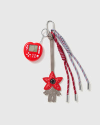Red Flower Game Stack Charm with a red flower, red handheld-game motif and red-and-grey cords on a light background