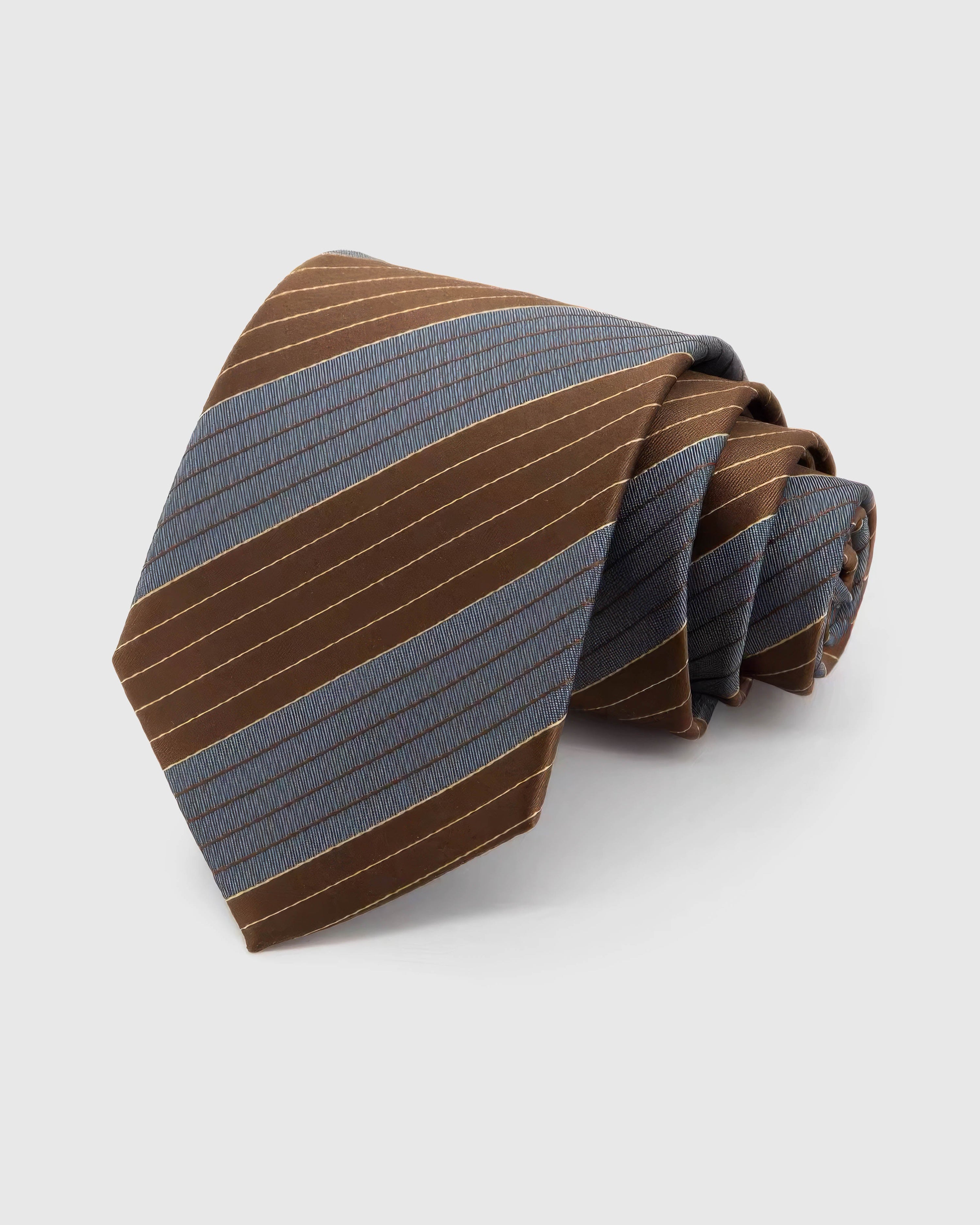 STICKYZOO Umber Slate Stripe Tie rolled on white, showing broad color-blocked diagonal stripes across 100% mulberry silk in umber brown and slate blue