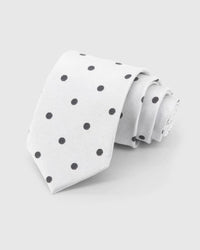 STICKYZOO Pearl Onyx Dot Tie rolled on white, showing onyx polka dots across 100% mulberry silk in pearl white