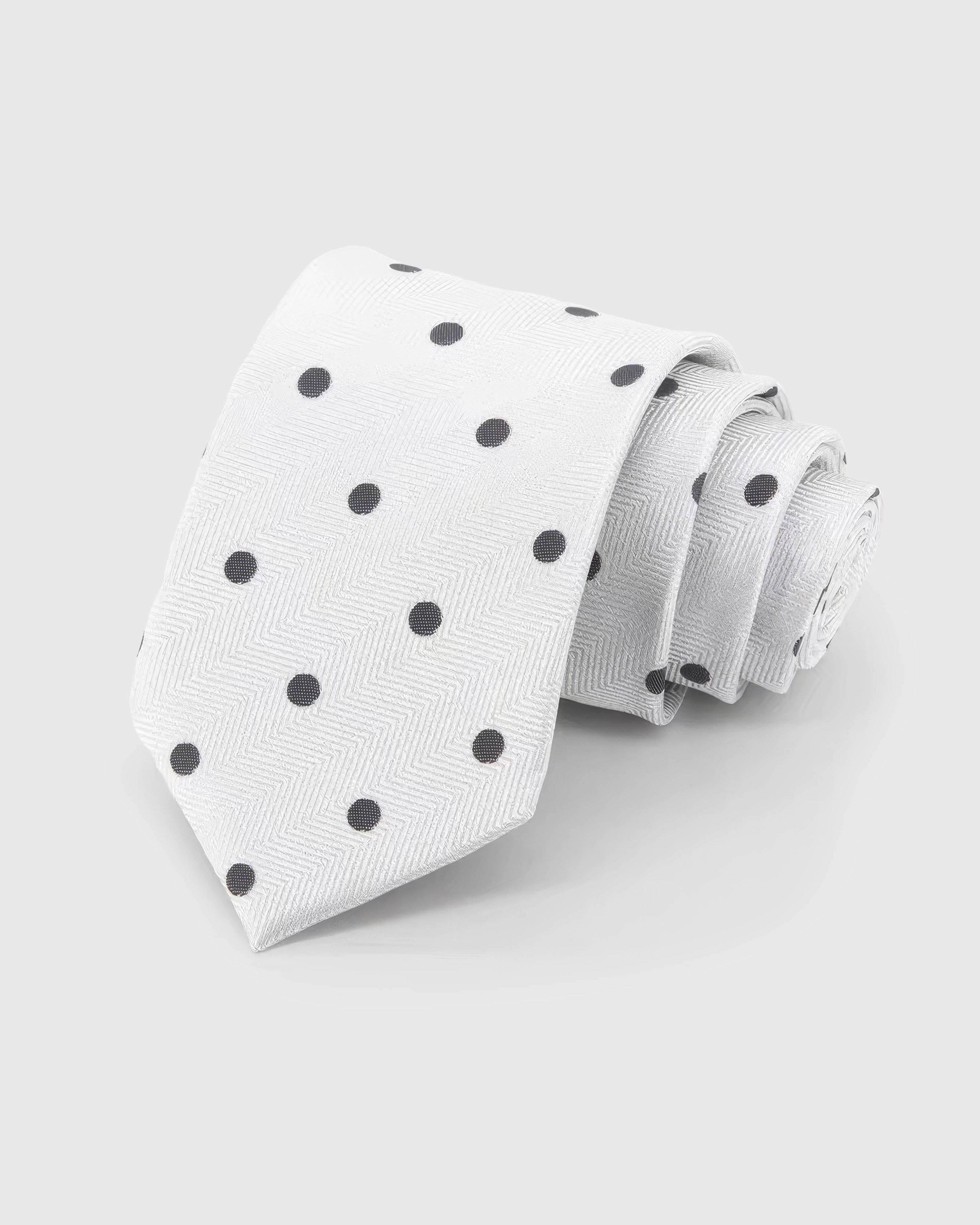 STICKYZOO Pearl Onyx Dot Tie rolled on white, showing onyx polka dots across 100% mulberry silk in pearl white