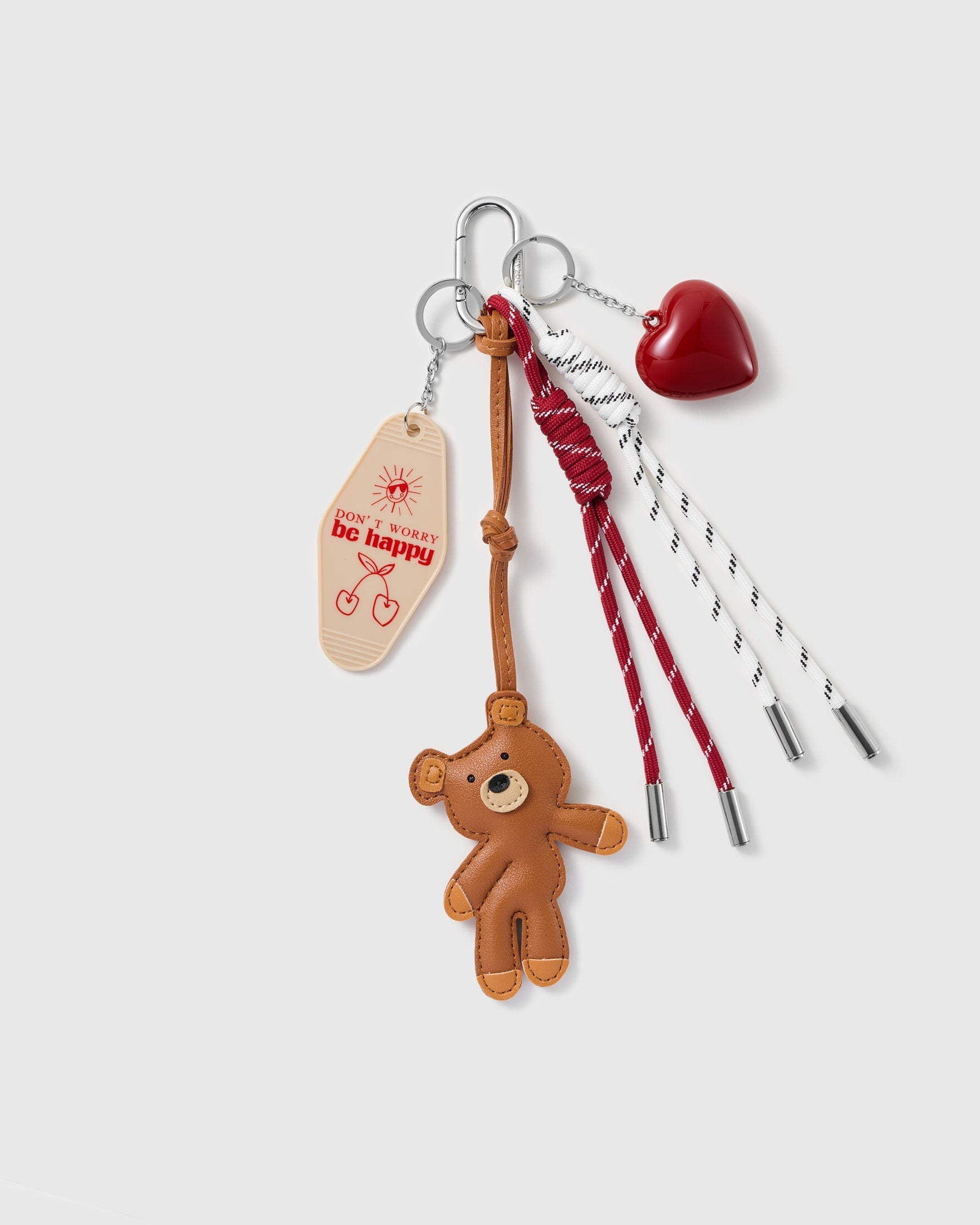 Teddy Heart Message Stack Charm with a brown teddy, red heart, positive-message tag and red-and-white cords on a light background