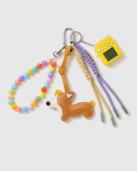 Corgi Arcade Bead Stack Charm with a brown-and-white corgi, yellow handheld-game motif, pastel bead loop and purple cords on a light background