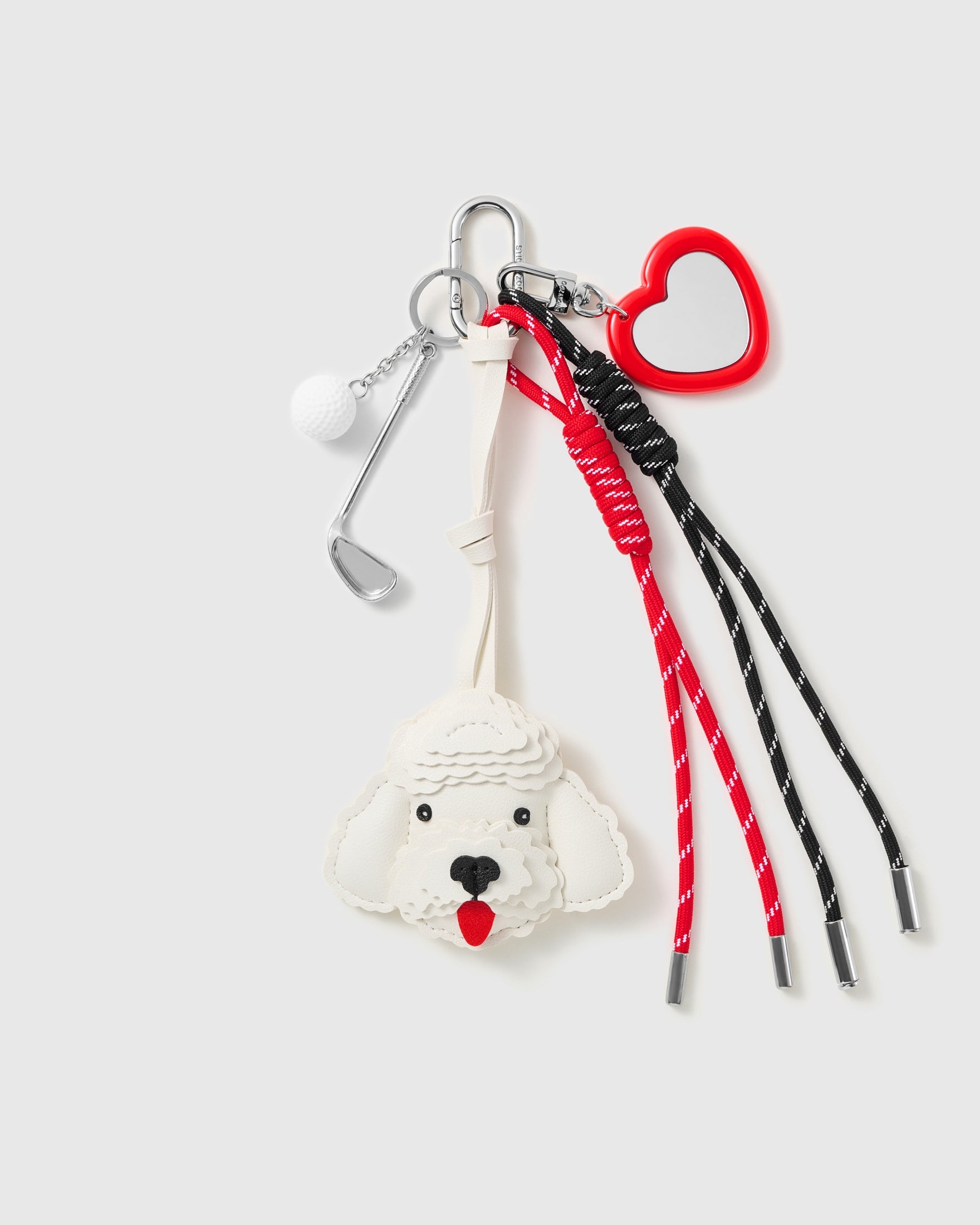 White Poodle Golf Stack Charm with a white poodle face, golf motifs, red heart outline and red-and-black cords on a light background
