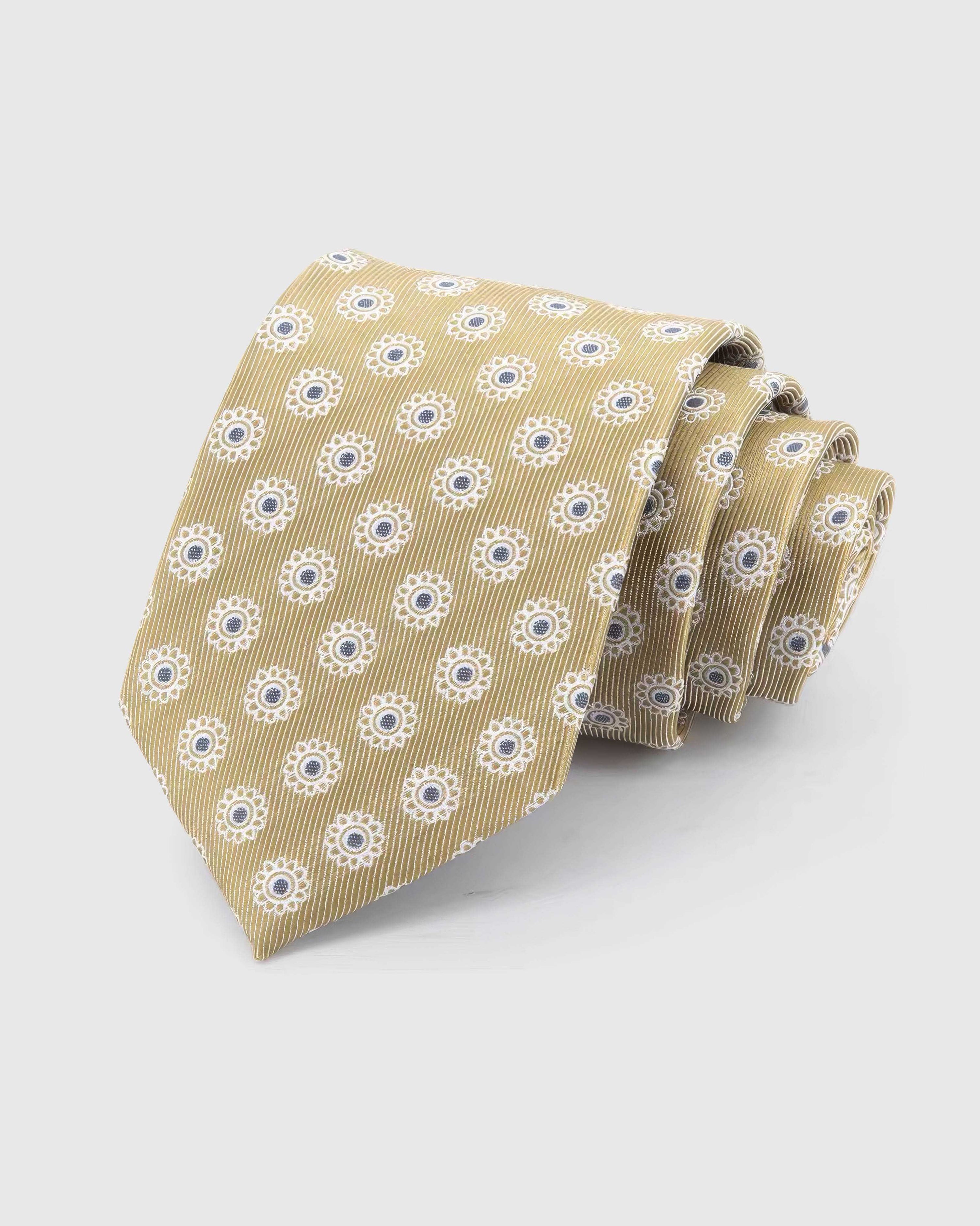 STICKYZOO Champagne Sunburst Tie in champagne and ivory silk, rolled to show champagne ground with ivory sunbursts and slate centres across the blade.