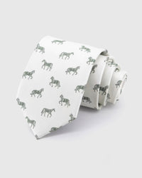 STICKYZOO Ivory Equestrian Tie in ivory silk, rolled to show ivory ground with sage and forest horse silhouettes across the blade.
