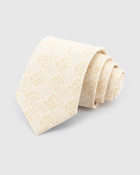 STICKYZOO Ivory Gilded Grid Tie rolled on white, showing an ivory field crossed by a pale-gold, softly irregular grid across the front blade.