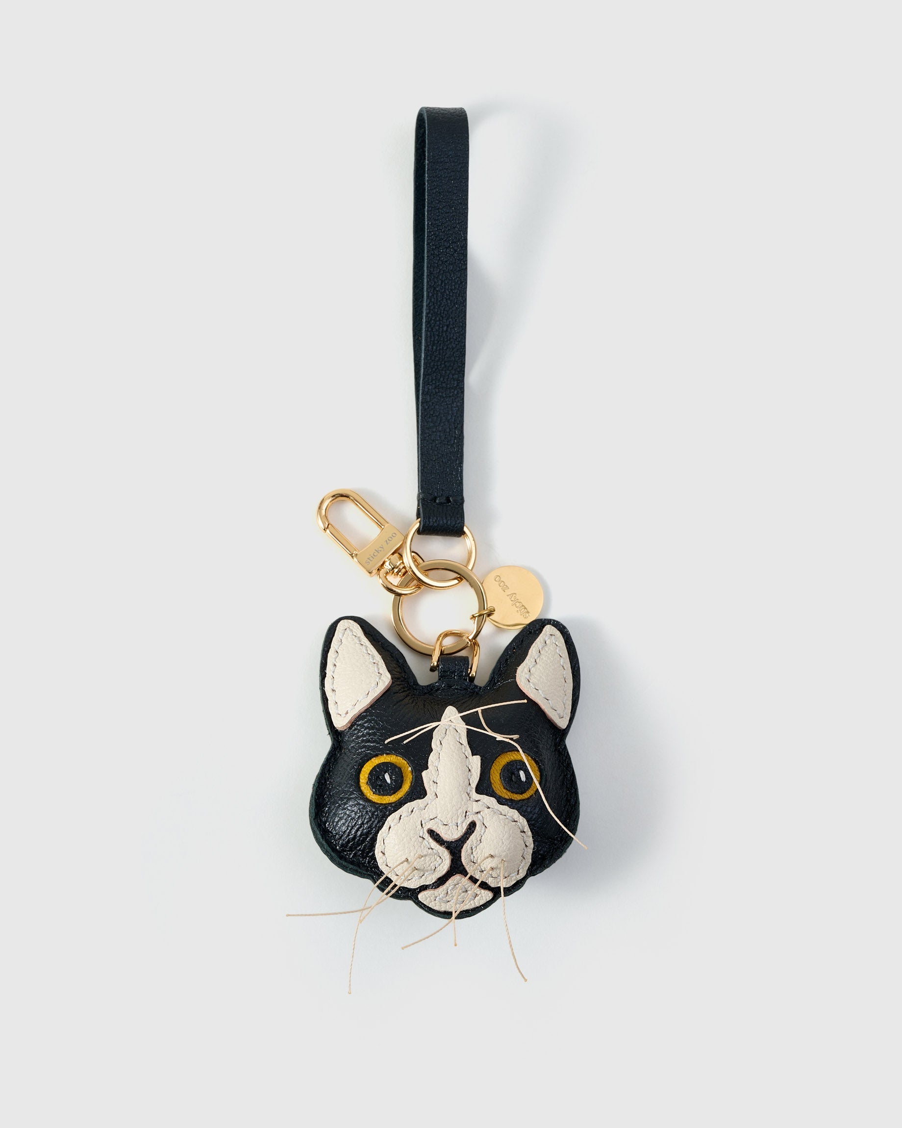Tuxedo cat on an 18K gold-plated keychain clip with engraved STICKYZOO disc — clips to keys, bags or backpacks.