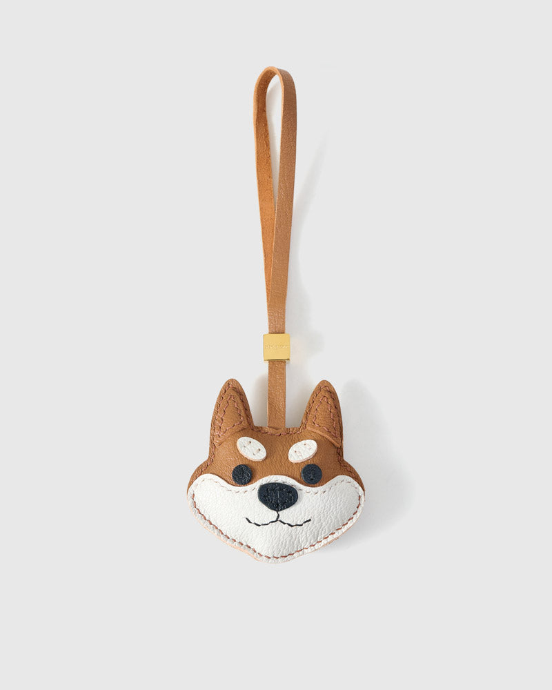 Orange Tokyo Shiba charm handmade from French Alran genuine goatskin and French suede — real full-grain leather from Tarn, since 1903. 3 days of hand-cutting, hand-stitching, hand-layering. Arrives in luxury gift packaging. Designed in Amsterdam.
