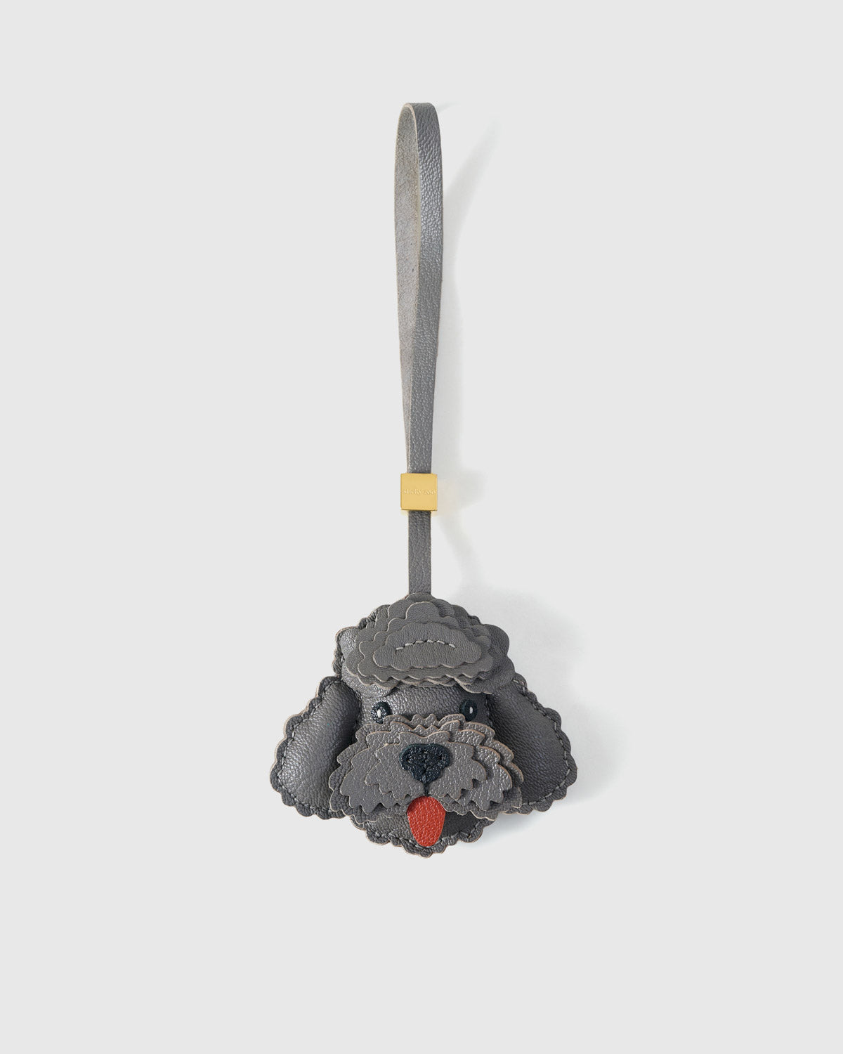 Handmade Poodle leather bag charm clipped to a leather handbag — French Alran goatskin, hand-cut and hand-stitched. STICKYZOO.