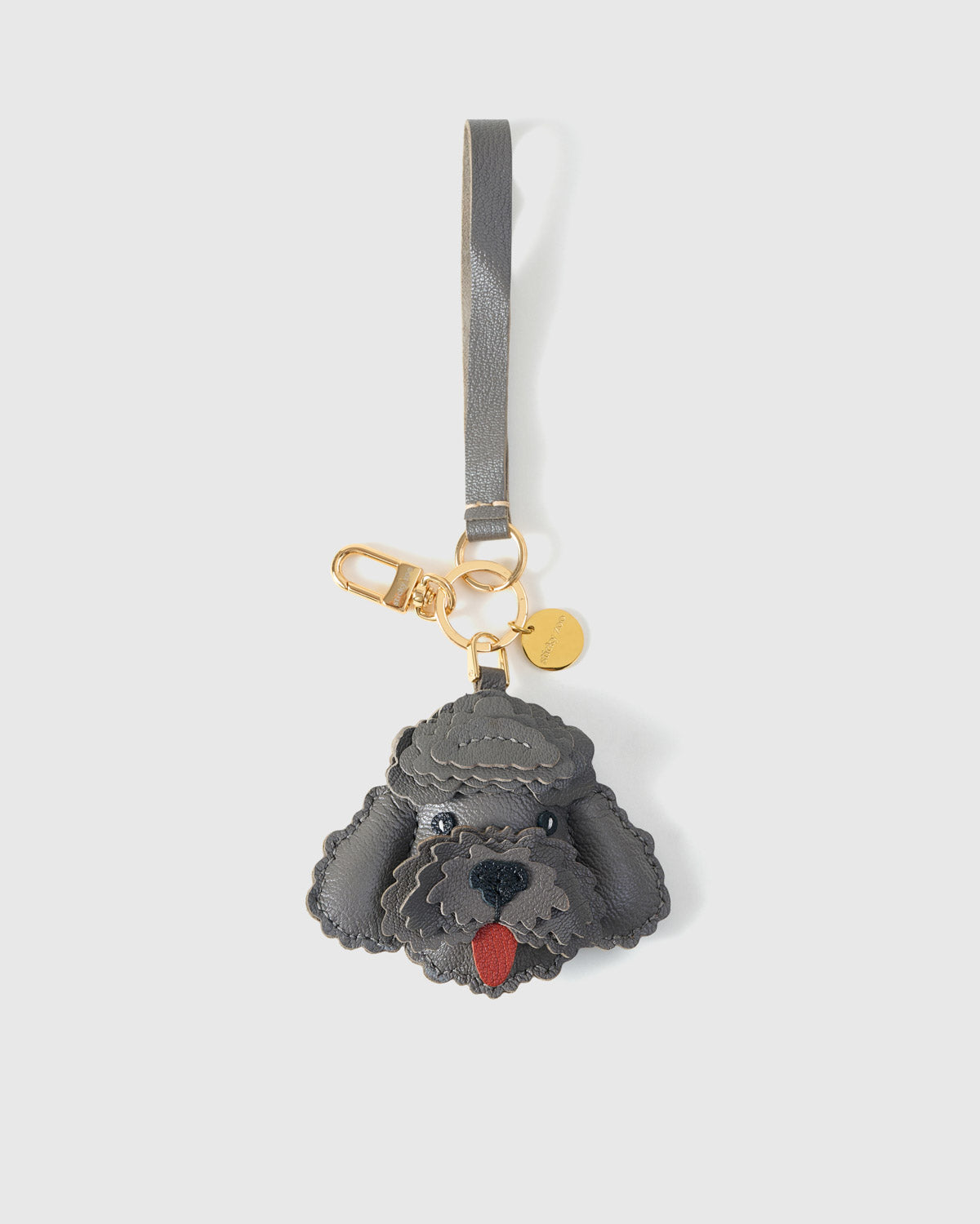 Handmade Poodle leather bag charm shown on a handbag — French Alran goatskin, 18K gold-plated hardware. STICKYZOO Amsterdam design.
