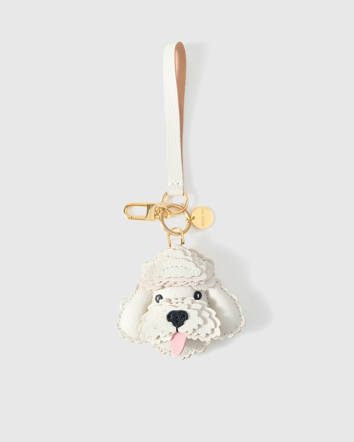 Poodle leather bag charm in both attachment formats — leather strap with engraved 18K gold cube and 18K gold-plated keychain clip. Handmade French Alran goatskin.