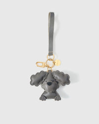 Poodle leather bag charm in both attachment formats — leather strap with engraved 18K gold cube and 18K gold-plated keychain clip. Handmade French Alran goatskin.