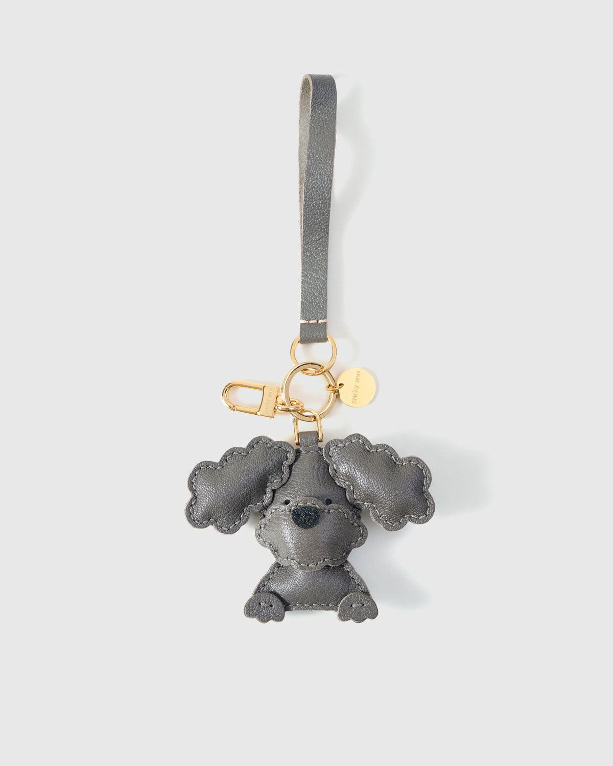Poodle leather bag charm in both attachment formats — leather strap with engraved 18K gold cube and 18K gold-plated keychain clip. Handmade French Alran goatskin.