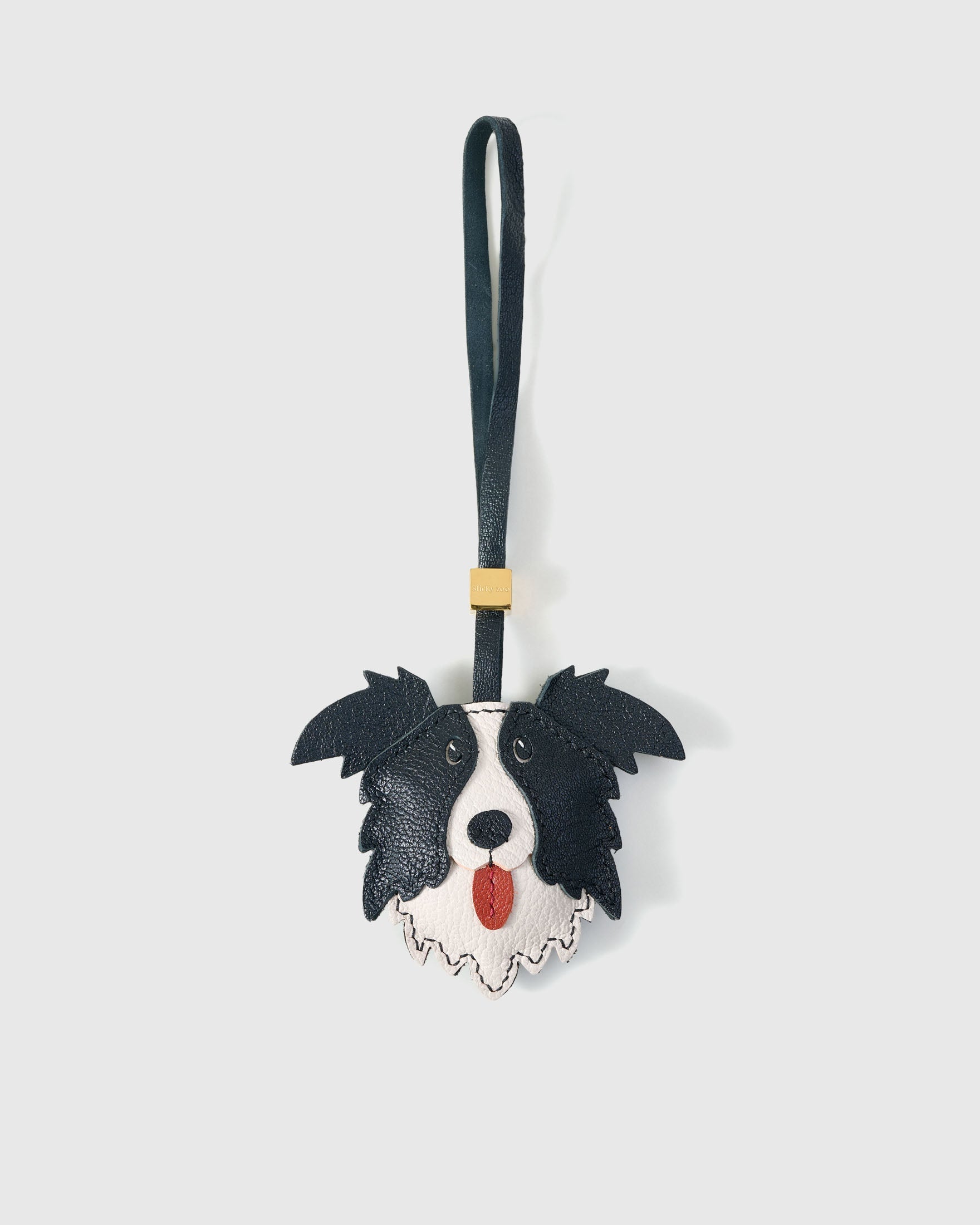 Border Collie charm handmade from French Alran genuine goatskin and French suede — real full-grain leather from Tarn, since 1903. 3 days of hand-cutting, hand-stitching, hand-layering. Arrives in luxury gift packaging. Designed in Amsterdam.