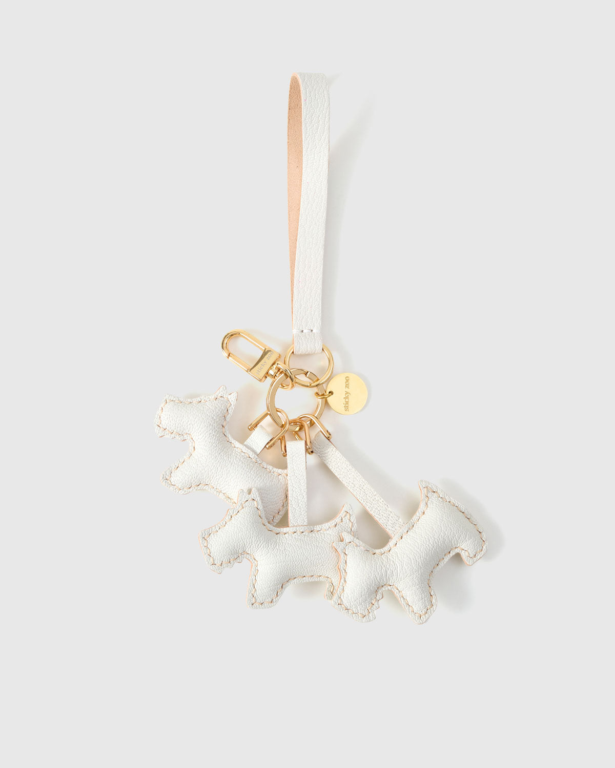 Worn on a bag, the triple schnauzer charm is the small, specific piece that people stop and point at.