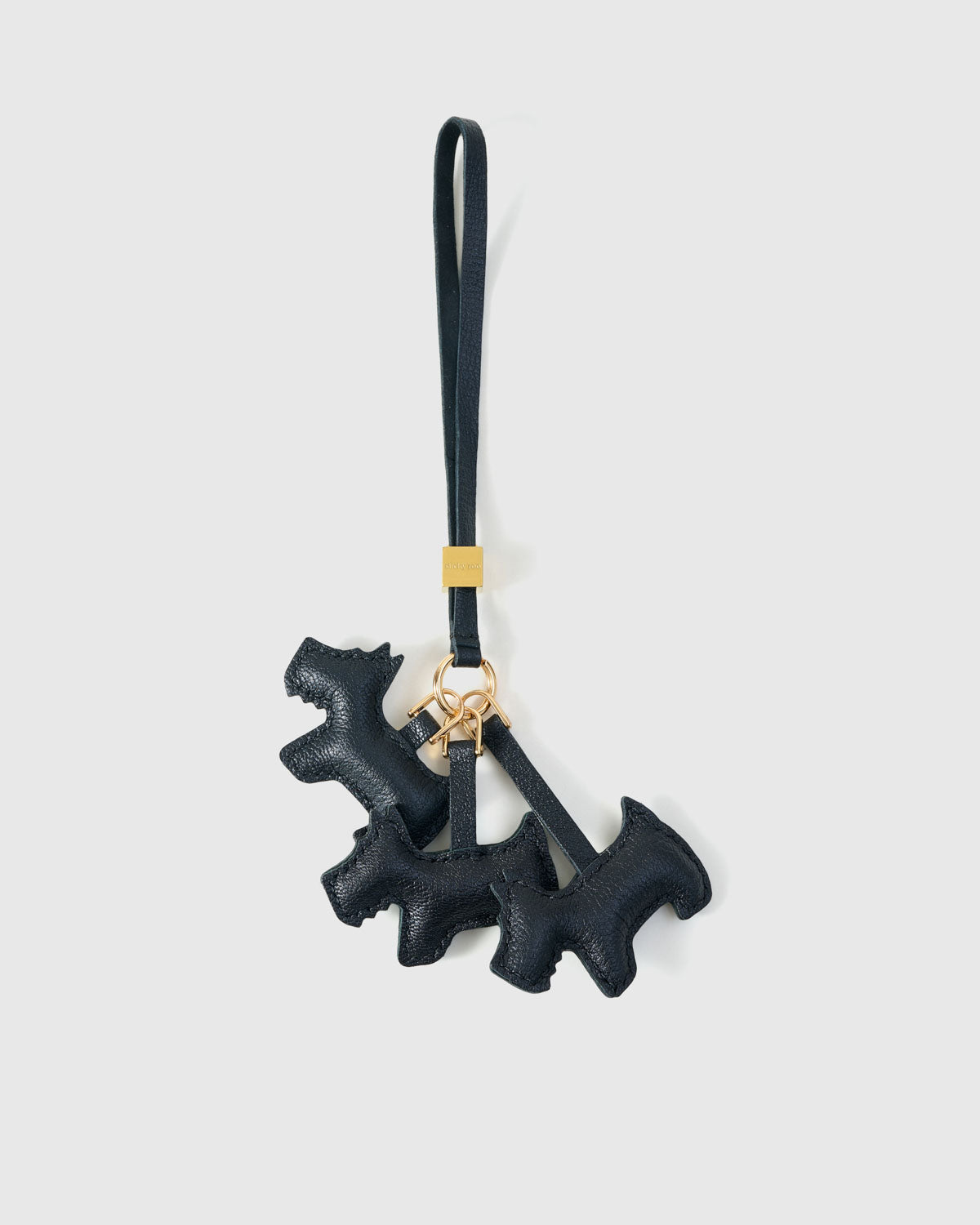Triple Schnauzer charm handmade from French Alran genuine goatskin and French suede — real full-grain leather from Tarn, since 1903. 3 days of hand-cutting, hand-stitching, hand-layering. Arrives in luxury gift packaging. Designed in Amsterdam.