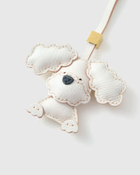 Handmade Poodle leather bag charm clipped to a handbag — French Alran goatskin, 3-day artisan build. STICKYZOO Amsterdam design.