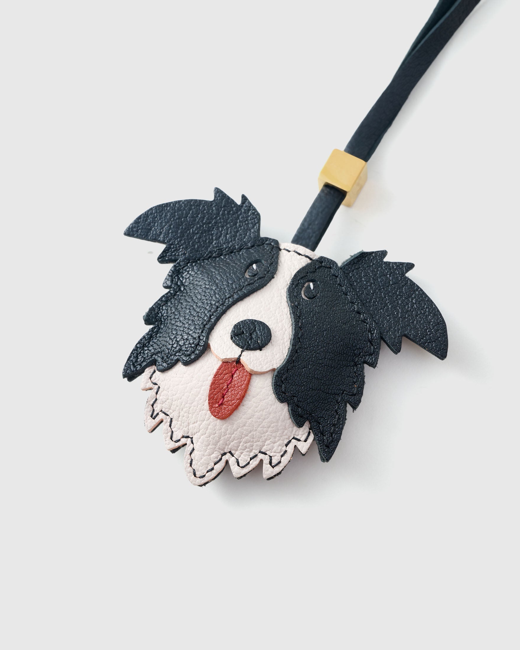 The border collie charm is made from genuine French Alran goatskin and French suede — real full-grain leather. Never vegan. Never synthetic. The difference shows.