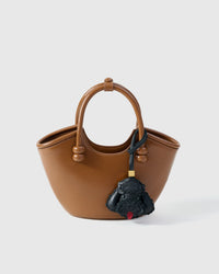 Handmade Poodle leather bag charm clipped to a handbag — French Alran goatskin, 3-day artisan build. STICKYZOO Amsterdam design.