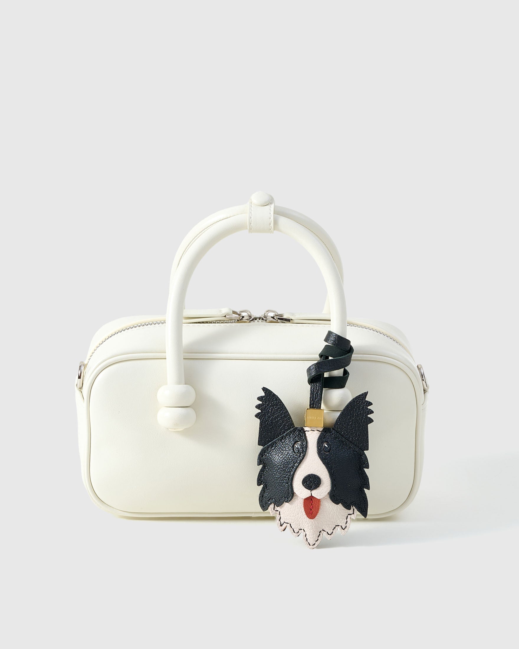 Wear the border collie charm on a bag with the leather strap loop, or clip it to keys with the 18K gold-plated keychain clip.