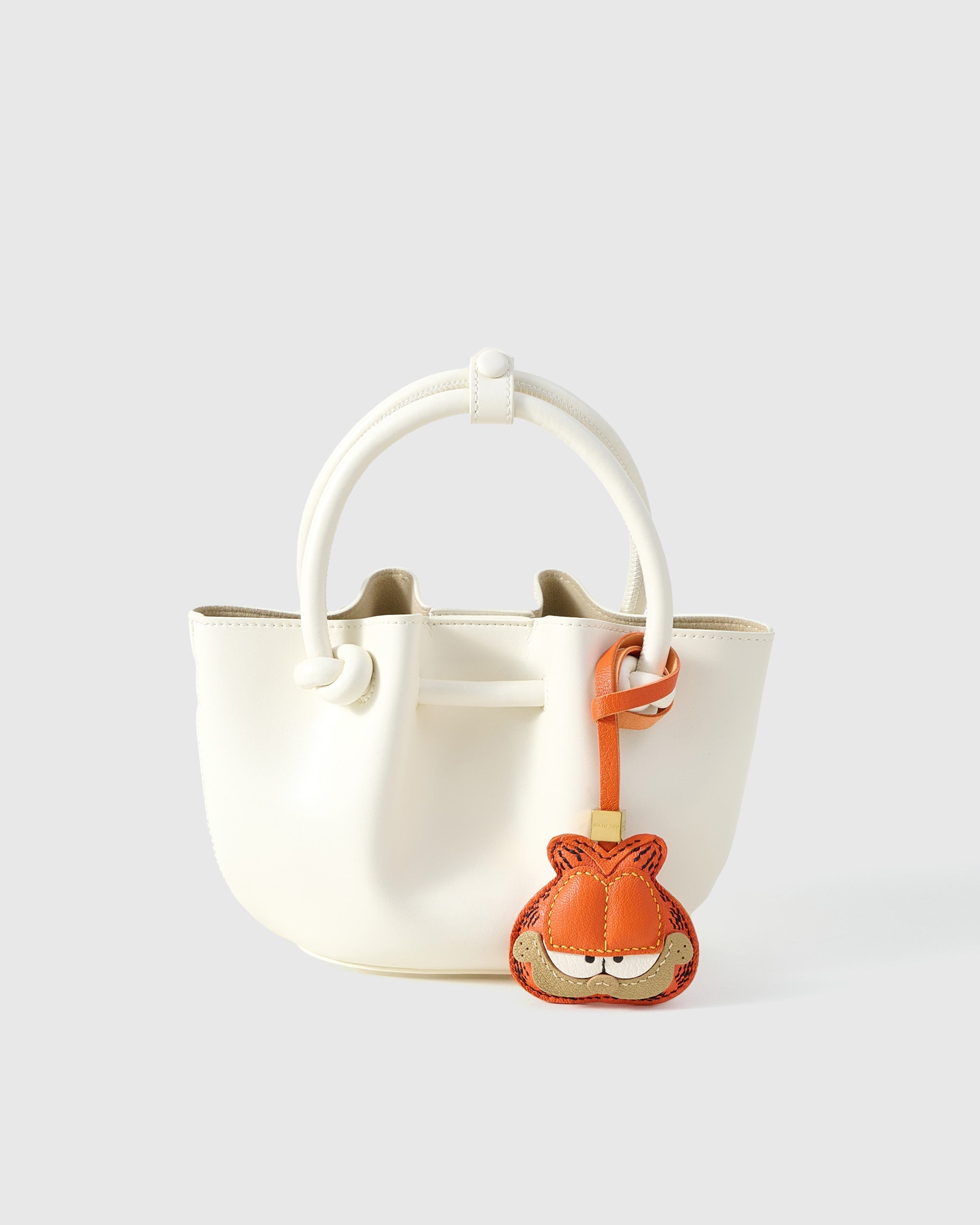 Garfield charm styled on a bag, front — a small, specific piece that turns a simple bag into a personal one.