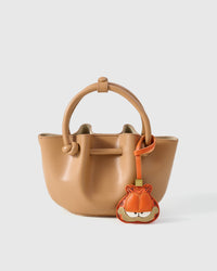 Close-up of the Garfield charm — hand-stitched tabby stripes, half-closed eyes, the correct level of resignation in real leather.