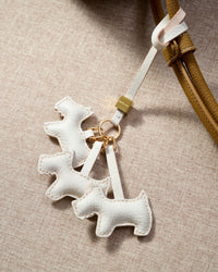 The triple schnauzer charm is made from genuine French Alran goatskin and French suede — real full-grain leather. Never vegan. Never synthetic. The difference shows.