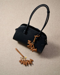 The triple schnauzer charm is made from genuine French Alran goatskin and French suede — real full-grain leather. Never vegan. Never synthetic. The difference shows.