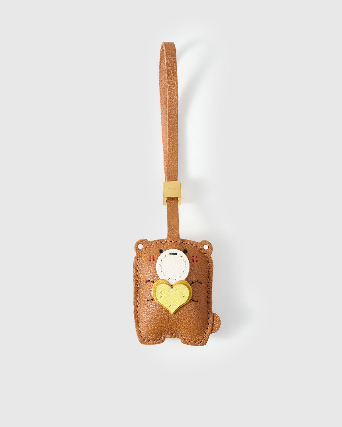 TEDDY BEAR CHARM charm handmade from French Alran genuine goatskin — A teddy bear holding a heart, eyes closed, completely at. Three days by hand. Arrives in luxury gift packaging. Designed in Amsterdam.