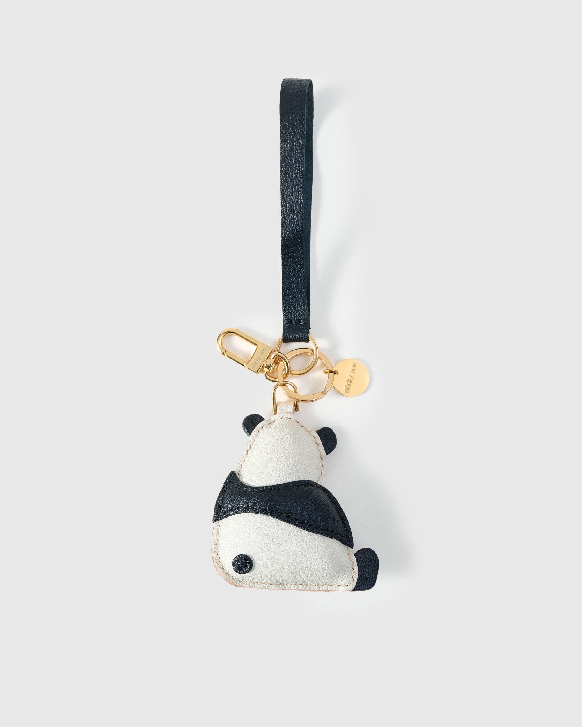 Both editions of the panda charm — leather strap loop for bags, or 18K gold-plated keychain clip.