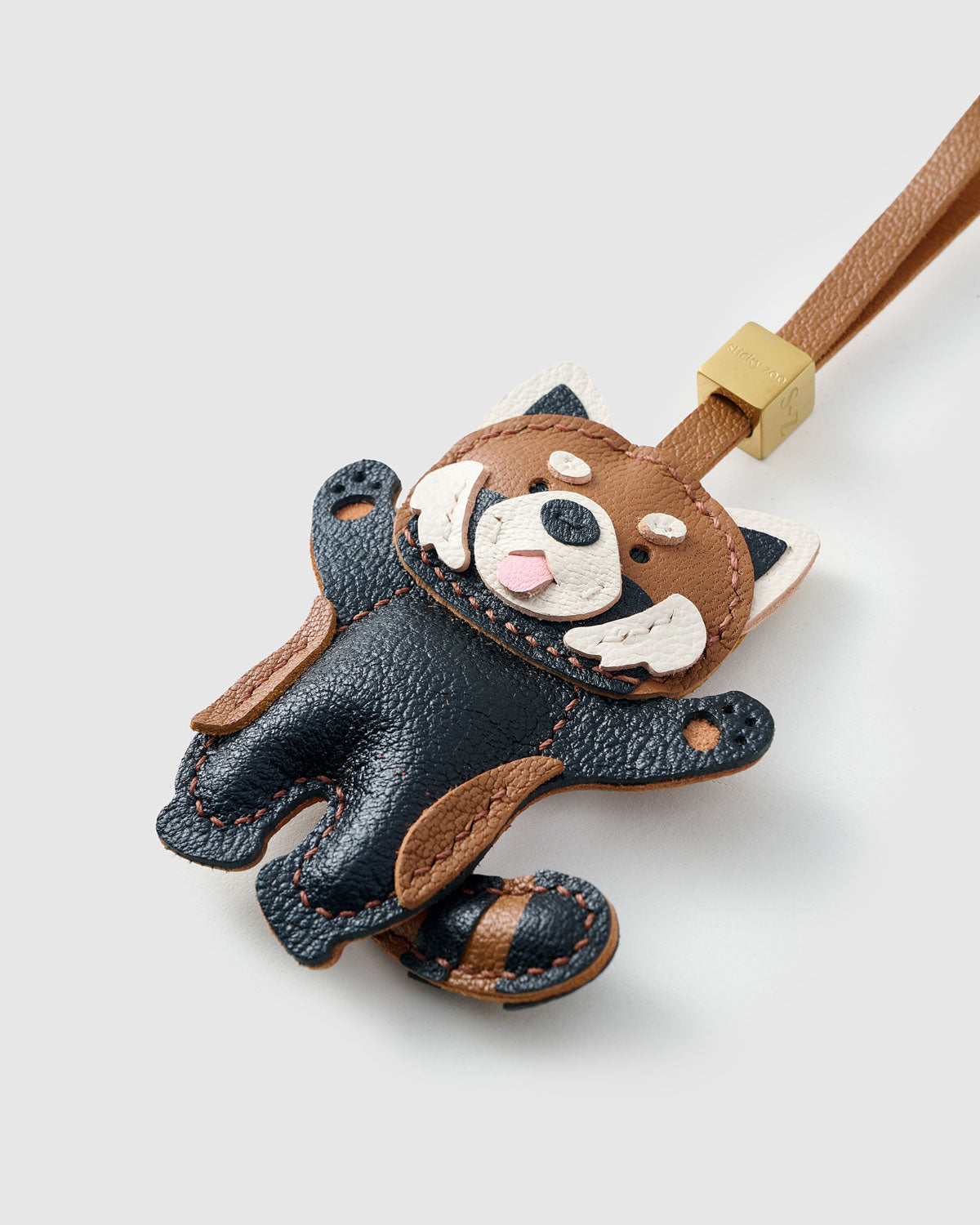 Close-up of the red panda charm — hand-cut and hand-stitched panels of French Alran goatskin. Every layer by hand.